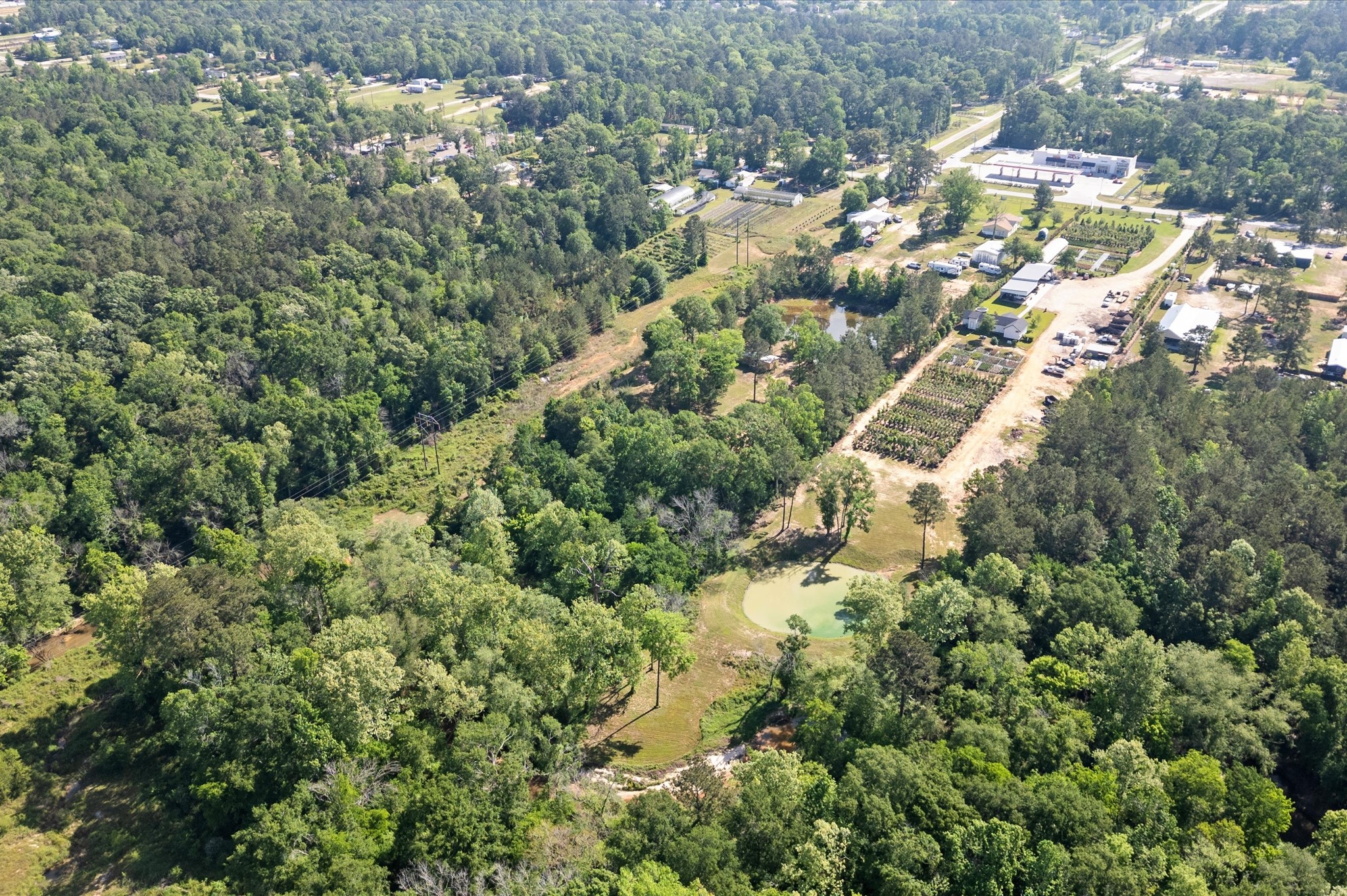 an aerial view of residential house with outdoor space and trees all around