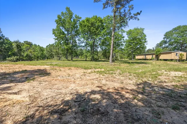 an aerial view of residential houses with outdoor space and trees