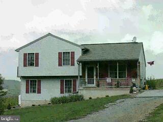 11643 Grim Road Felton, PA 17322 - Photo 1 of 1 a view of a white house with a large windows and a yard with plants and large trees