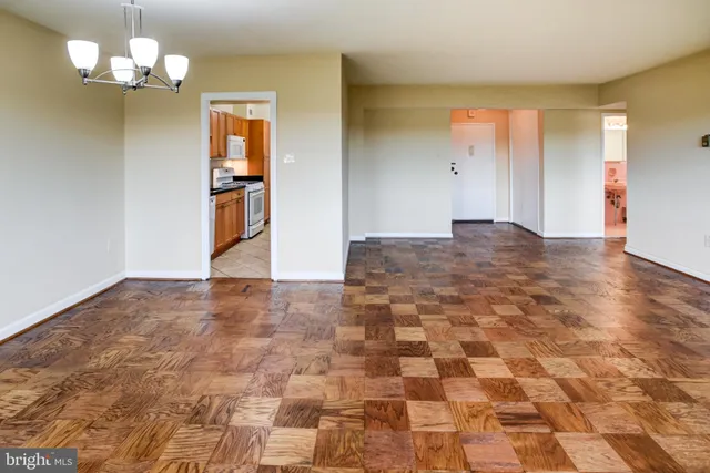 a view of empty room with a chandelier and wooden floor