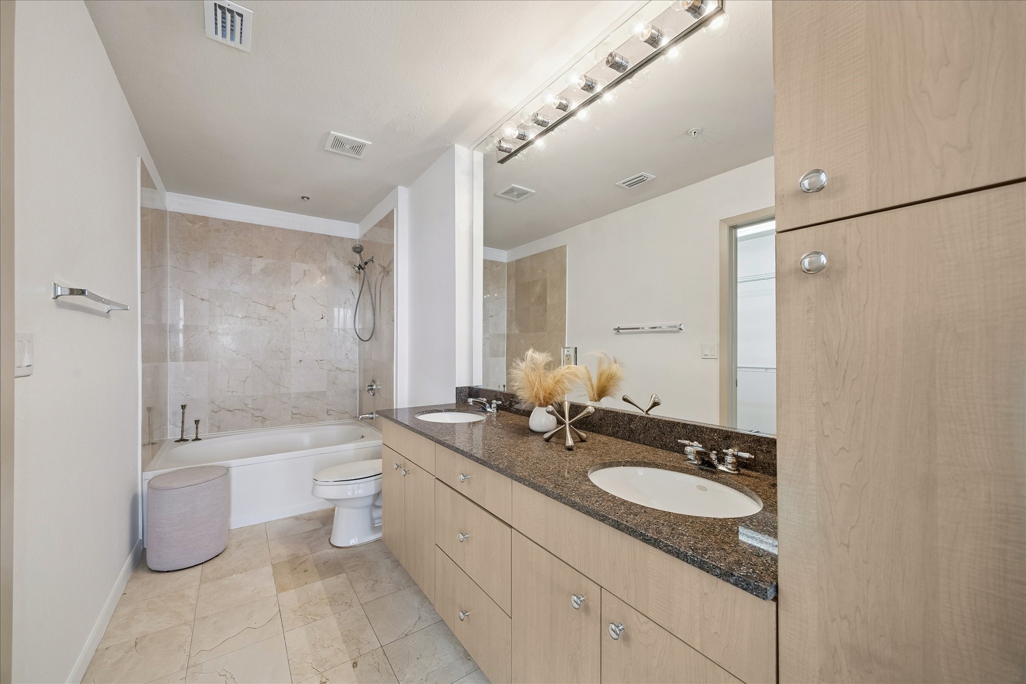 3505 Sage Road, Unit 2810 Houston, TX 77056 - Photo 11 of 26 a bathroom with a granite countertop sink a toilet a bathtub and shower
