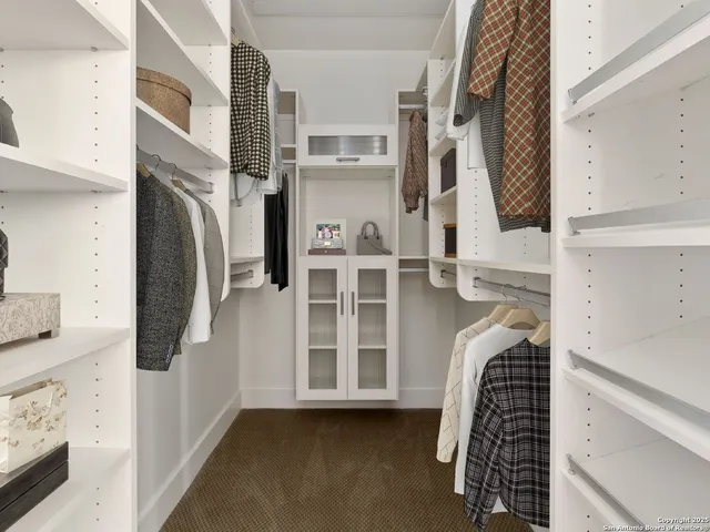 a view of walk in closet with clothes and shoes