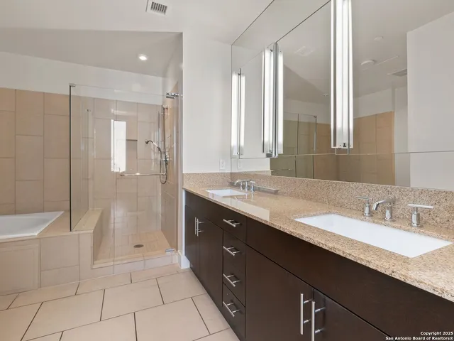 a bathroom with a granite countertop sink mirror and shower