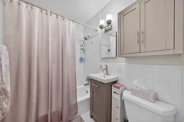 a bathroom with a sink a toilet and shower curtain