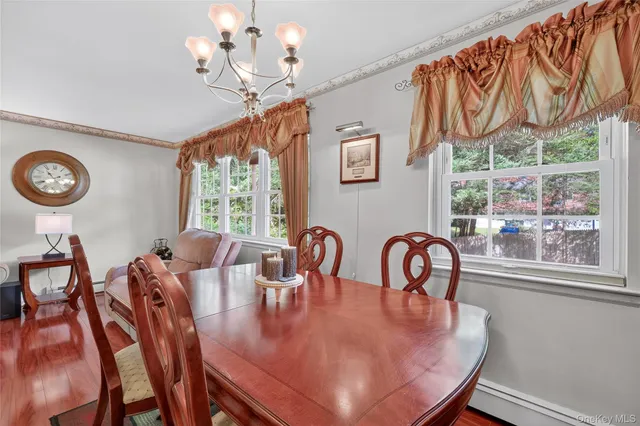 a dining room with furniture a large window and a chandelier