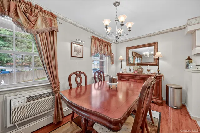 a dining room with furniture a chandelier and wooden floor