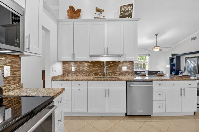 a kitchen with granite countertop a sink a stove and cabinets