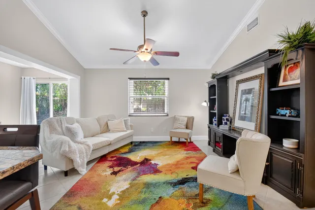a living room with furniture ceiling fan and a window