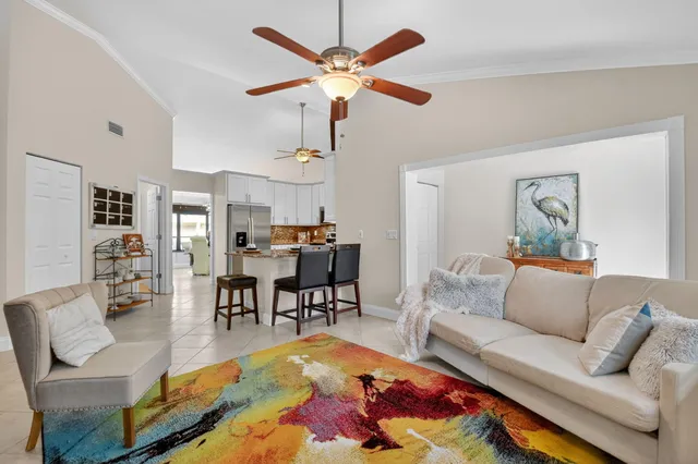 a living room with furniture kitchen view and a chandelier