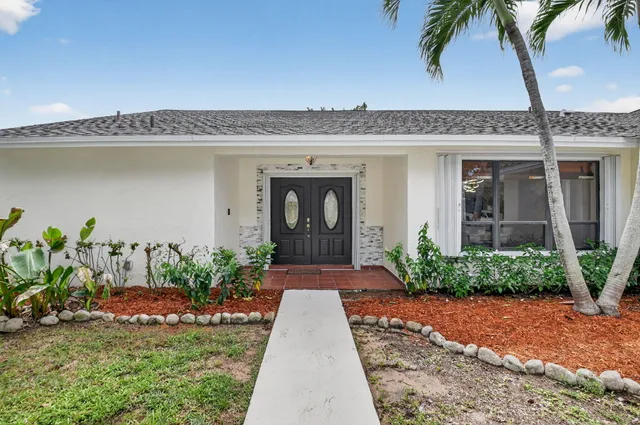 a front view of a house with a garden