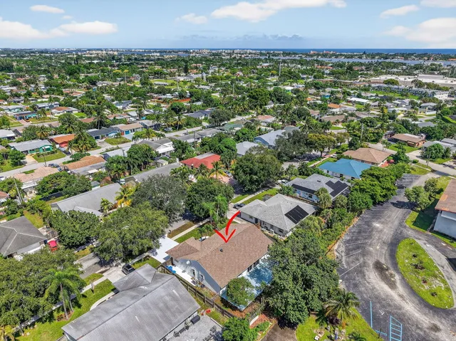 an aerial view of residential houses with outdoor space and trees