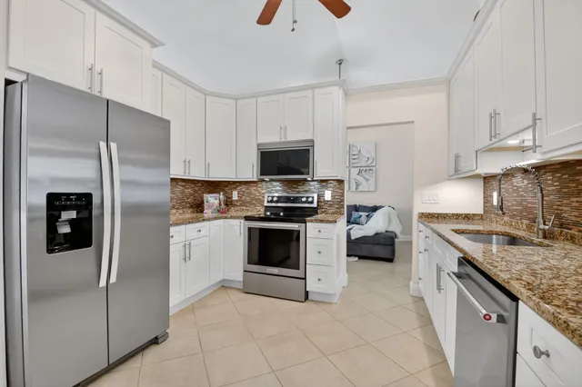 a kitchen with stainless steel appliances granite countertop a refrigerator stove and a sink