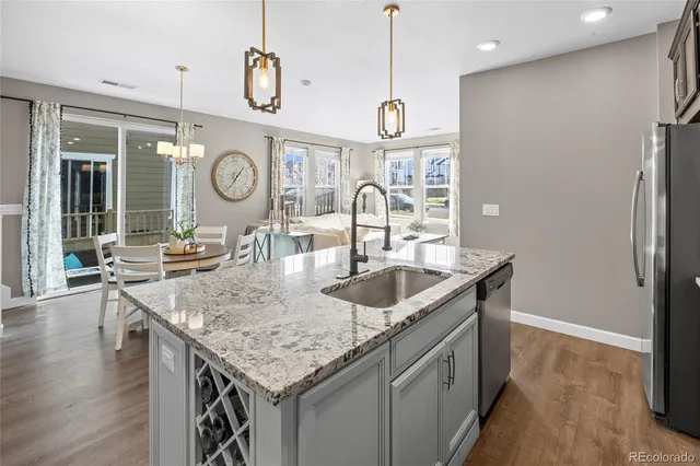 a kitchen with stainless steel appliances granite countertop a sink refrigerator and cabinets