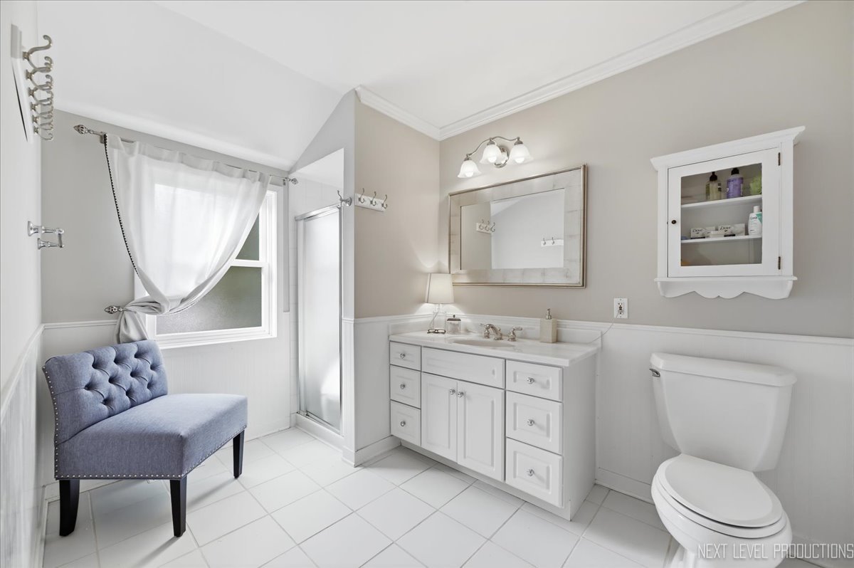 629 Peck Road Geneva, IL 60134 - Photo 28 of 38 a bathroom with a granite countertop toilet a sink a mirror a and a window