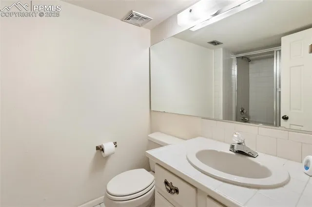 a bathroom with a sink a toilet and mirror