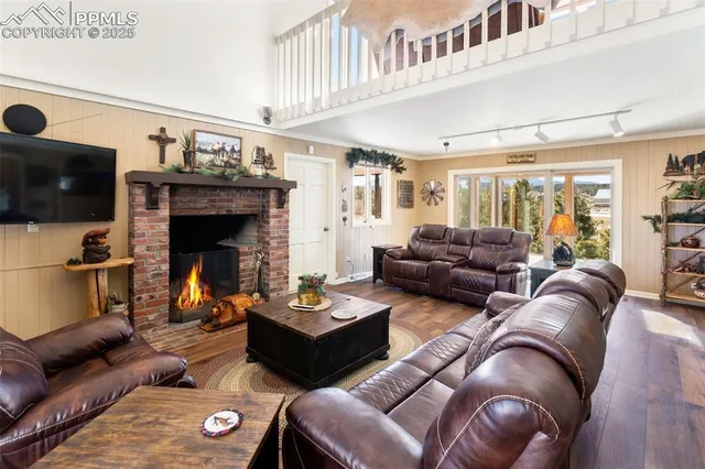 a living room with furniture a flat screen tv and a fireplace