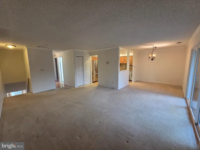 a view of a big room with windows and chandelier fan
