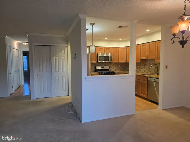 a kitchen with stainless steel appliances kitchen island granite countertop a refrigerator and a sink