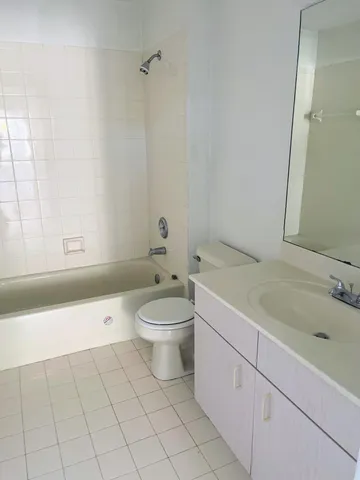 an empty room with windows and chandelier fan