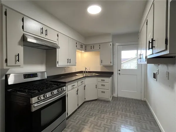a kitchen with stainless steel appliances granite countertop a stove a sink and a refrigerator