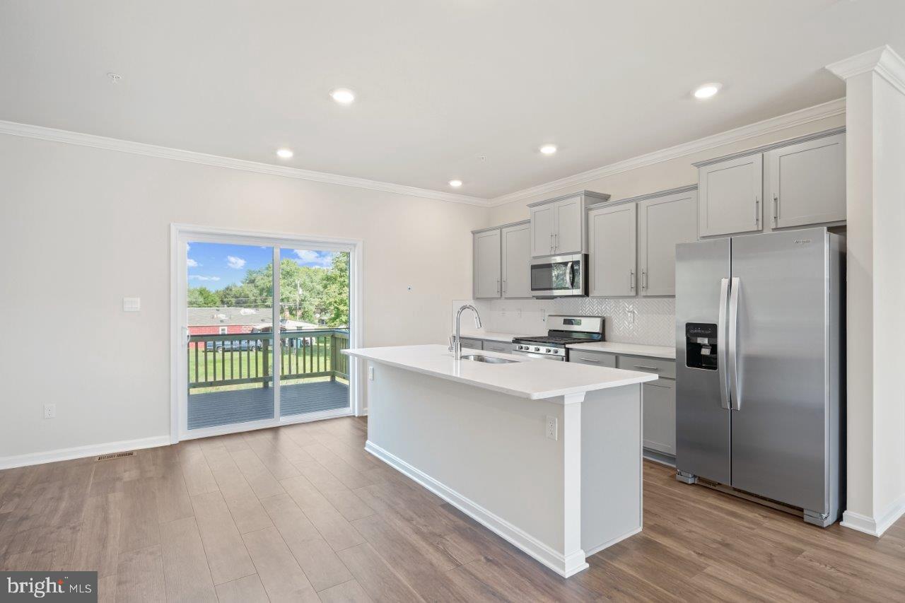 7519 Silver Thread Way Brandywine, MD 20613 - Photo 8 of 32 a kitchen with stainless steel appliances a sink a stove a refrigerator cabinets and a large window