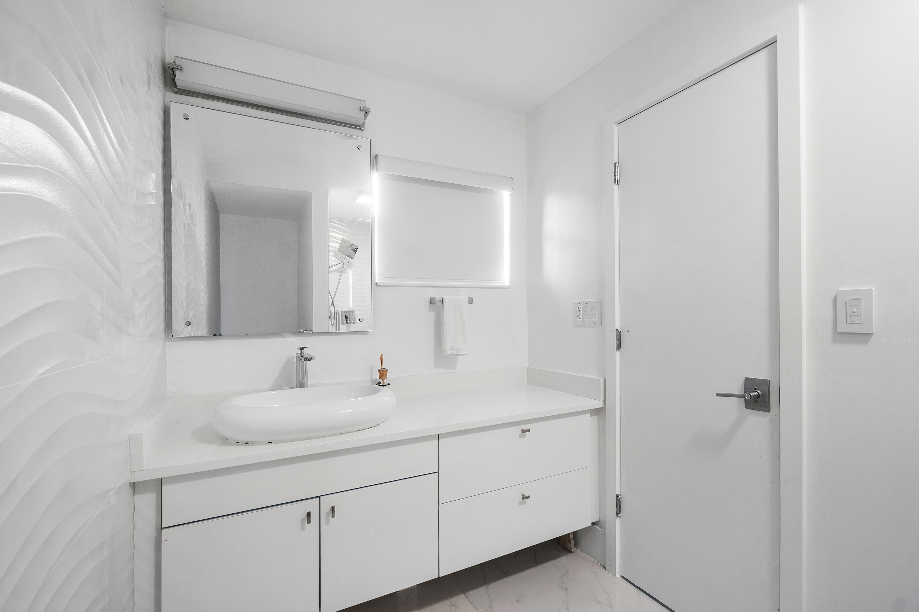 5447 Center Street Jupiter, FL 33458 - Photo 25 of 60 a bathroom with a sink and a mirror