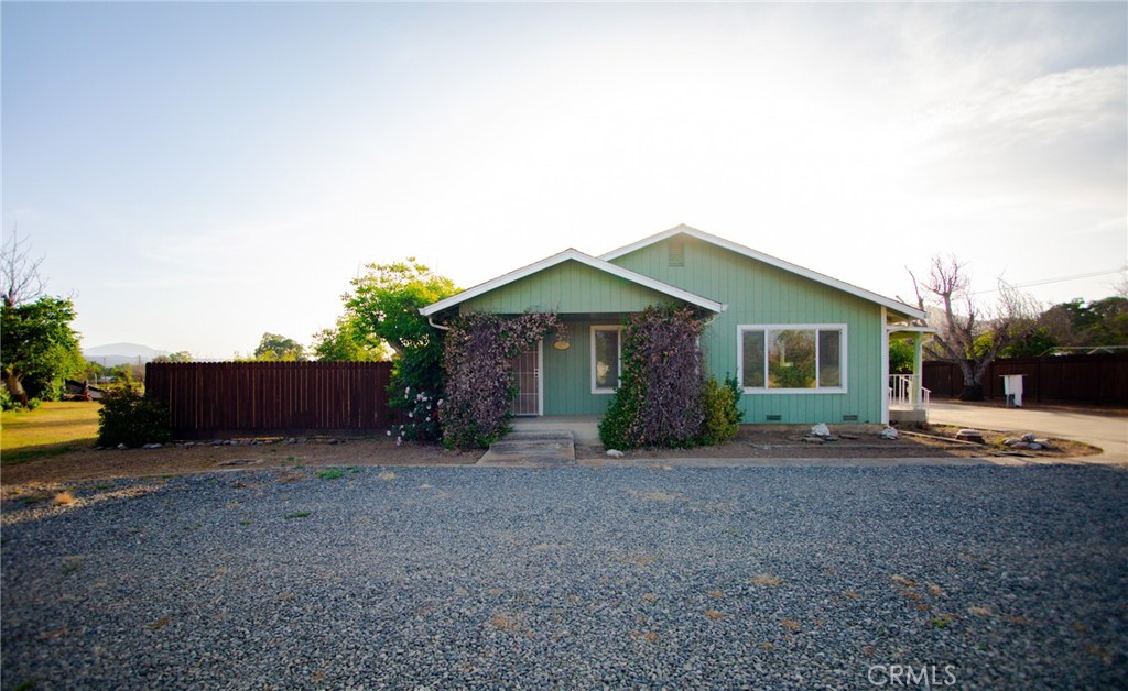 a front view of house with yard and trees in the background