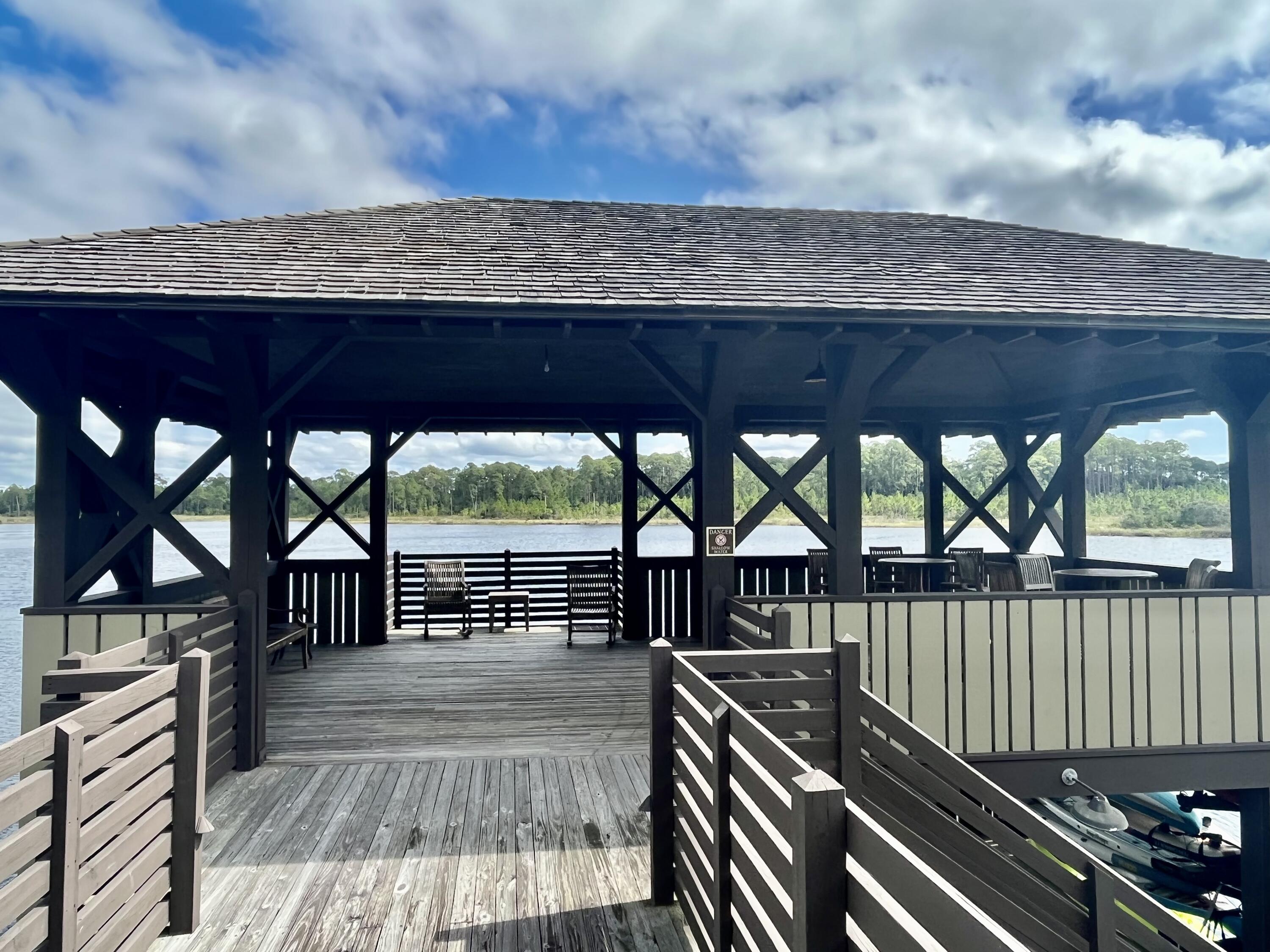 2-4 West Cedar Bend Road Santa Rosa Beach, FL 32459 - Photo 11 of 14 a view of a deck with wooden floor and roof with a barbeque grill