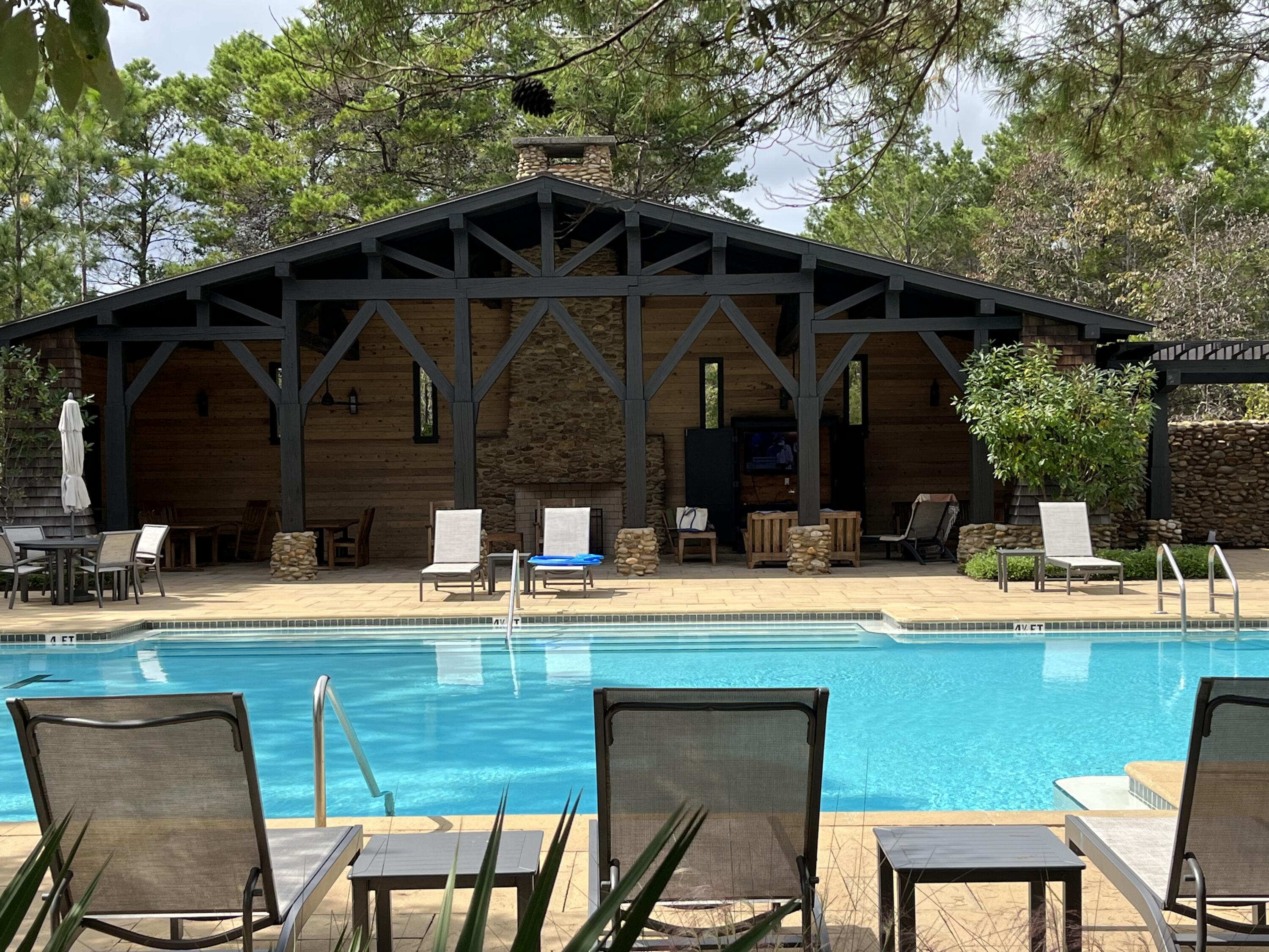 2-4 West Cedar Bend Road Santa Rosa Beach, FL 32459 - Photo 6 of 14 a view of a swimming pool with a lawn chairs under an umbrella