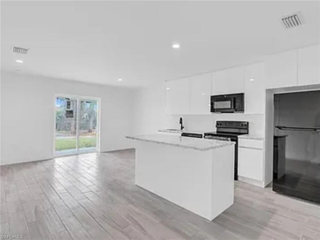 3120 Peters Avenue Naples, FL 34112 - Photo 3 of 12 a kitchen with stainless steel appliances a sink stove and refrigerator