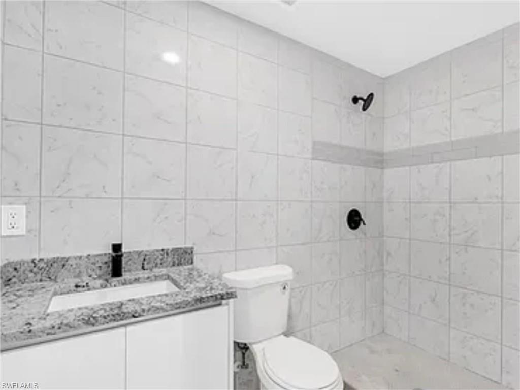 3120 Peters Avenue Naples, FL 34112 - Photo 6 of 12 a bathroom with a granite countertop sink a toilet and shower