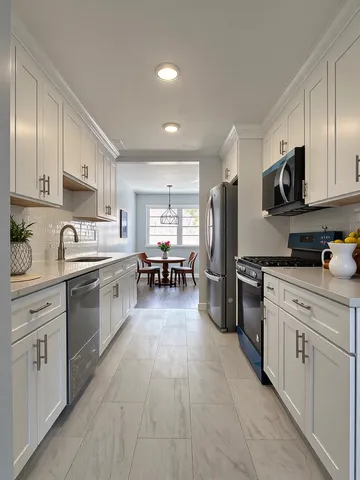 a kitchen with stainless steel appliances a refrigerator sink and microwave