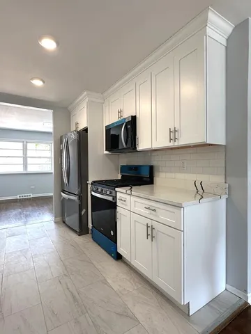 a kitchen with stainless steel appliances granite countertop a refrigerator and a stove top oven
