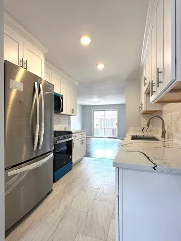 a kitchen with stainless steel appliances a refrigerator sink and stove