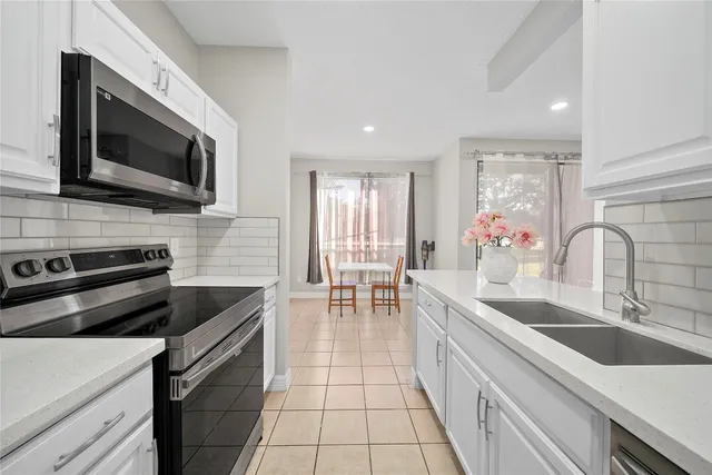 a kitchen with stainless steel appliances a stove sink microwave and cabinets