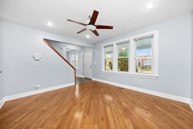 8100 South Houston Avenue Chicago, IL 60617 - Photo 5 of 55 a view of an empty room with wooden floor and a window