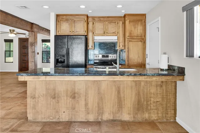 a view of kitchen with stainless steel appliances granite countertop a stove a sink and a refrigerator