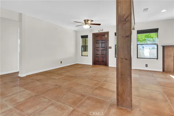 a view of an empty room with a fireplace and a window