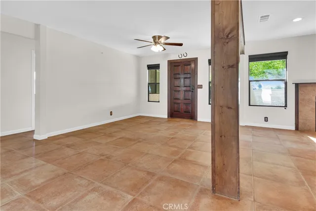 a view of an empty room with a fireplace and a window
