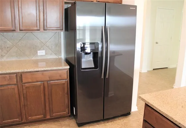 a close view of a refrigerator in kitchen and a wooden floor