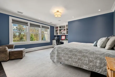 a bedroom with a bed couch and a large window