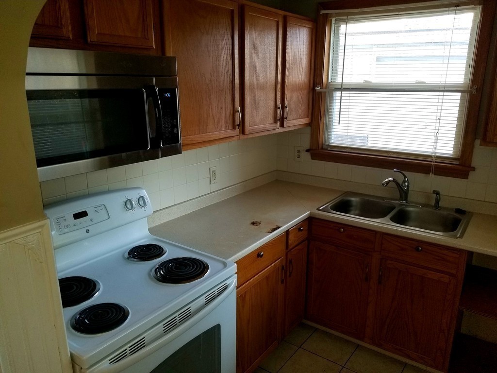 126 Ridge Street Fall River, MA 02721 - Photo 13 of 28 a kitchen with a stove and a microwave