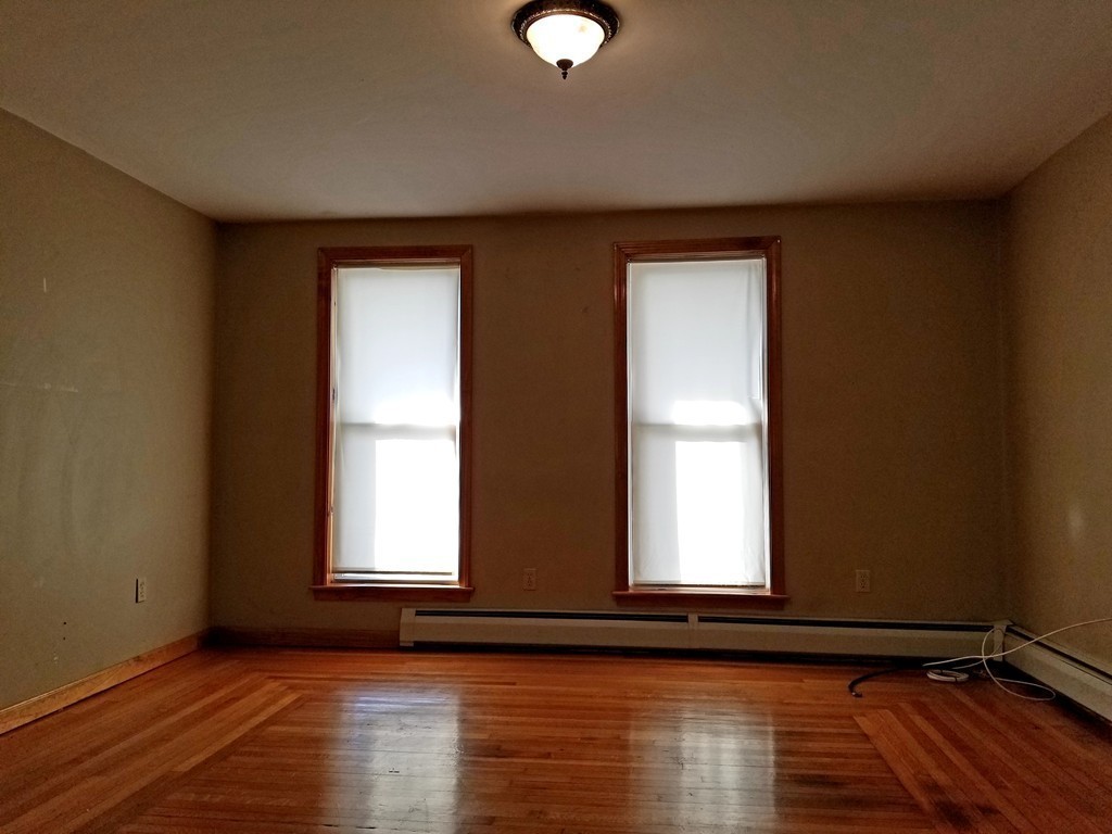 126 Ridge Street Fall River, MA 02721 - Photo 8 of 28 a view of empty room with wooden floor and fan