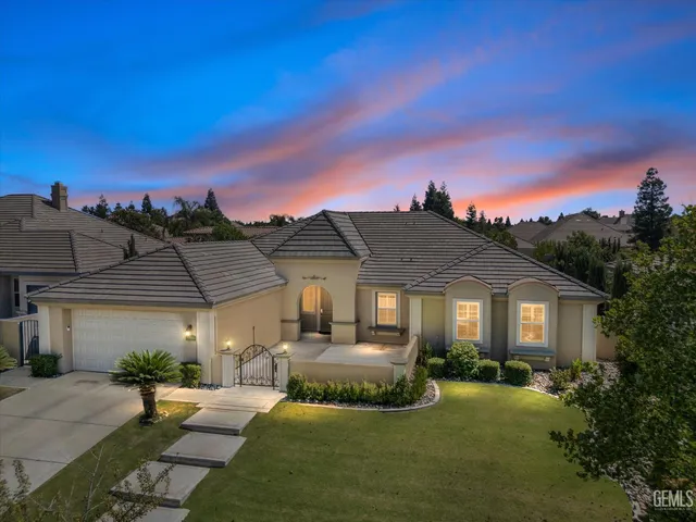 a front view of a house with a garden and yard