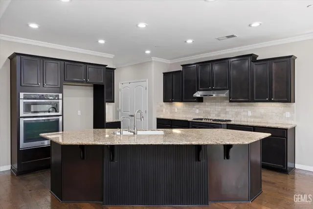 a kitchen with stainless steel appliances granite countertop a stove a sink and a refrigerator