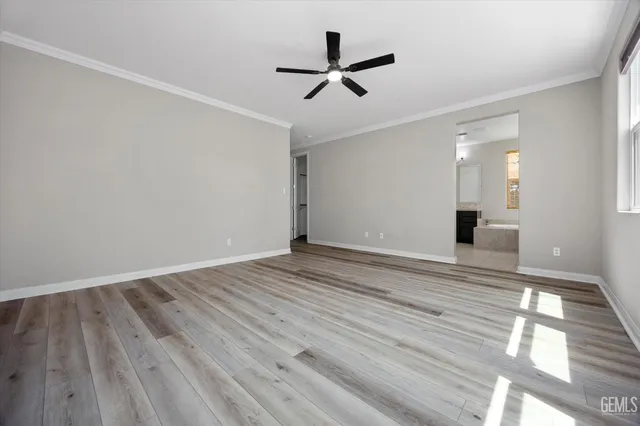 a view of a livingroom with wooden floor and a ceiling fan