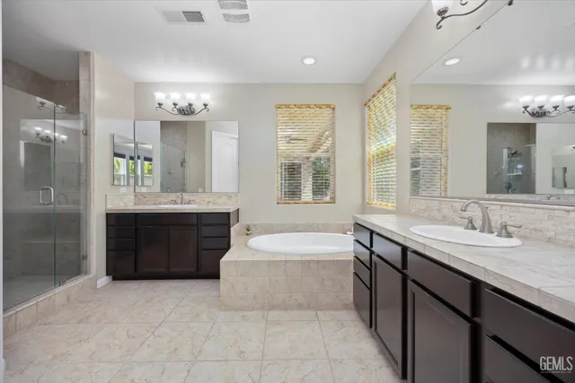 a spacious bathroom with a tub sink and mirror