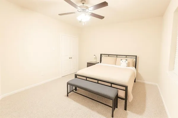 a bedroom with a bed and a ceiling fan