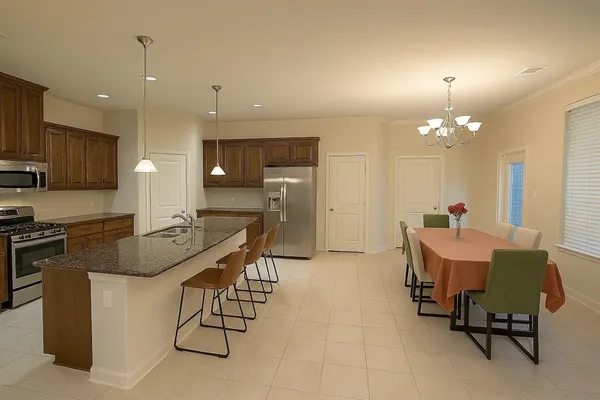 a dining room with furniture a chandelier and kitchen view
