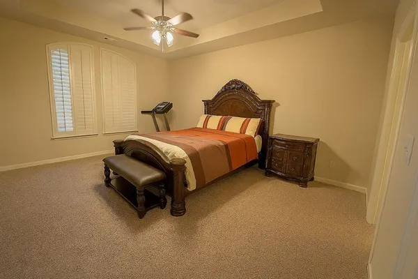 a spacious bedroom with a bed and a chandelier